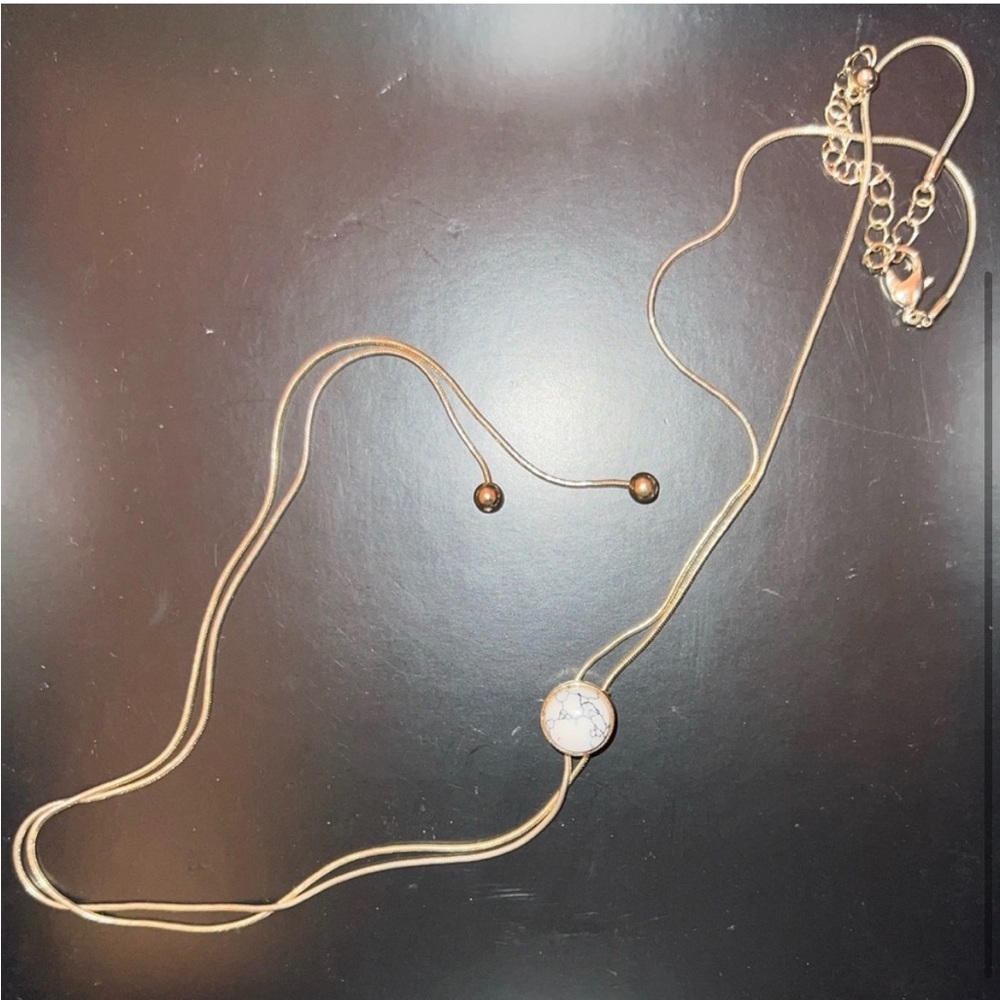 Gold bolo style necklace with marble center detail